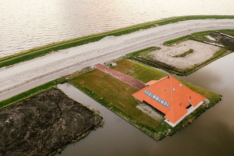 Luchtfoto van de stolp aan de Zeedijk, met de dijk en het IJsselmeer erachter