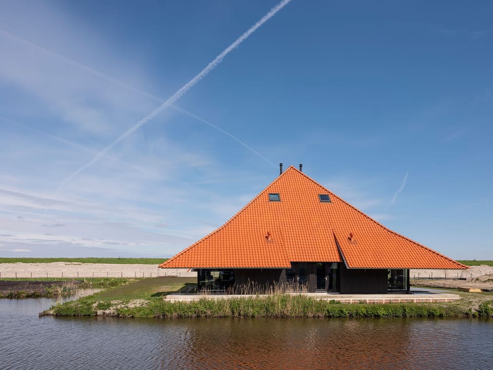 Stolp Zeedijk: stolpboerderij met oranjebruin piramidedak aan het water