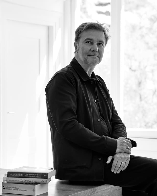 Portret van Theo Karkazis in zwart-wit, zittend